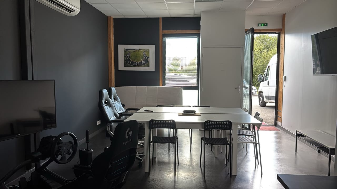 Salle de réunion du cowork ADAMYA avec baie vitrée et simulateur de course