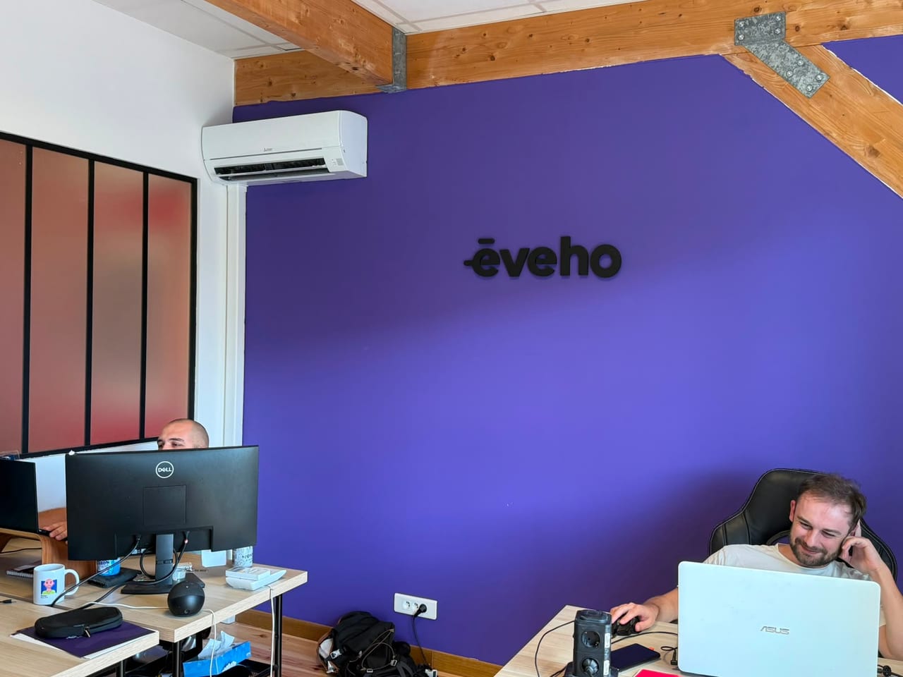 Coin eveho du cowork ADAMYA, mur violet signature et équipe au travail